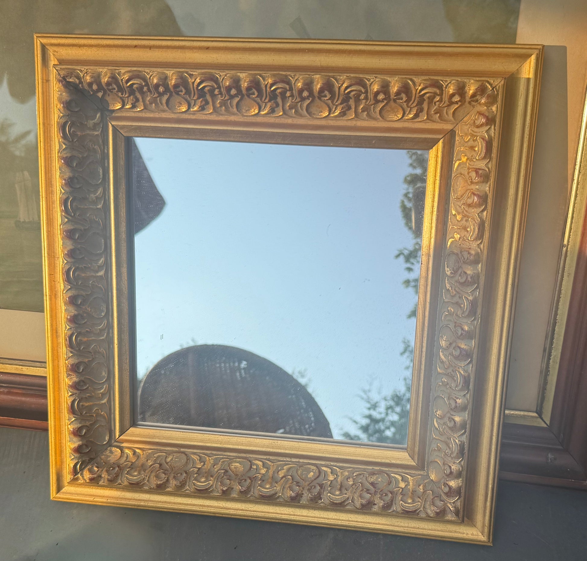 Decorative gold-framed mirror on a table